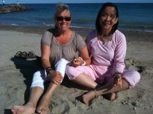 Anne et Francoise assises main dans la main dos à la mer