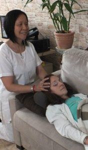 Méthode Reiki : Anne durant une séance, apposant ses mains sur la tête de la receveuse
