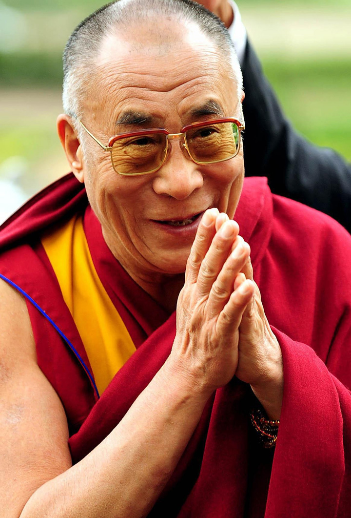 Le Dalaï-Lama, les mains en prières, souriant