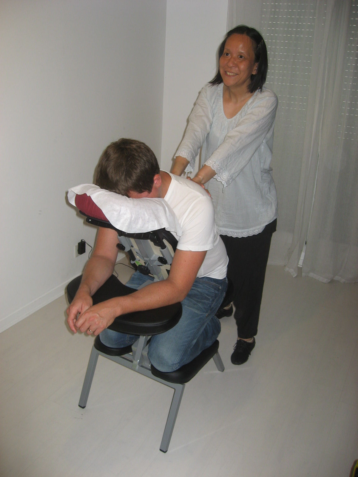 Anne effectuant un massage Amma assis sur un homme invité lors d'un événement privé